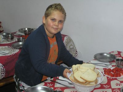 Ett av barnen hjälper till med frukostförberedelserna.